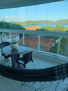 a balcony with a hammock and a table and chairs at Residencial pacific in Cabo Frio