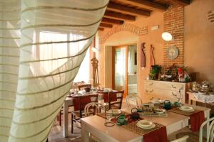 uma sala de estar com mesas e cadeiras e uma cozinha em Agriturismo Monte degli Aromi em Villaga