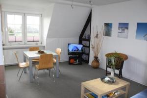 ein Wohnzimmer mit Tisch und Stühlen und einem Fernseher in der Unterkunft Wohnung in Gießelrade mit Großem Garten - b48578 in Ahrensbök + 1 Foto