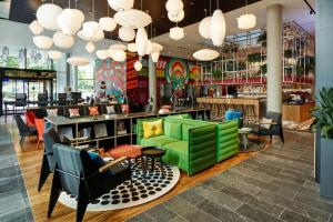 un restaurante con sillas verdes y un bar en citizenM Seattle South Lake, en Seattle