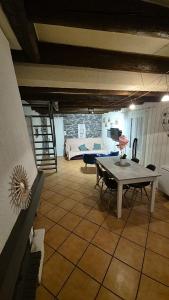 a living room with a table and a bed at Charmante maison près des bords de la Loire in Beaufort-en-Vallée