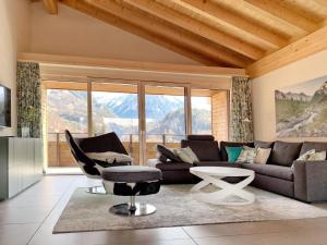 una sala de estar con un sofá y una silla en Mountain 4U, en Meiringen