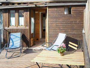 2 Stühle und ein Tisch auf einer Terrasse in der Unterkunft Stone Cabin With Views Over Balme Valley in Alo di Stura