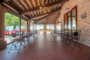 eine Terrasse mit Tischen und Stühlen in einem Gebäude in der Unterkunft Villa Ferrara Royal Resort & Spa in Coriano