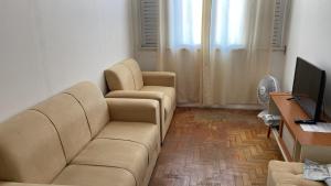 een woonkamer met een bank en een televisie bij Apartamento na Pituba in Salvador +10 foto's