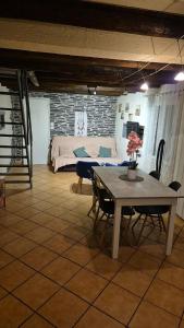 a room with a table and chairs and a bed at Charmante maison près des bords de la Loire in Beaufort-en-Vallée