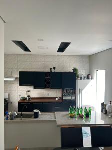Eine Küche mit schwarzen Schränken und grünen Flaschen auf der Arbeitsplatte in der Unterkunft Bene Home in Sinop
