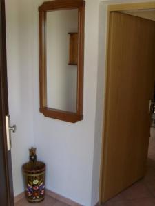 ein Spiegel an einer Wand neben einer Tür in der Unterkunft Ruhige Ferienwohnung mit Garten und Blick zur Wallfahrtskirche in Ebensfeld