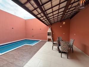 Zimmer mit Pool, Tisch und Stühlen in der Unterkunft Village GRAND LUX exclusivo com piscina privativa in Feira de Santana + 20 Fotos