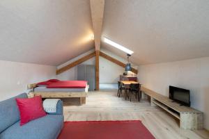 ein Zimmer mit einer Couch und einem Bett und einem Tisch in der Unterkunft Bijou - BioBergün - b48615 in Bergün