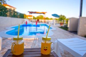 two jars of honey on a table near a pool at Ferienhaus In Opanci Mit Beheiztem Pool, Parkplatz in Lovreć +24 photos