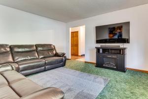 a living room with a leather couch and a flat screen tv at 4 Mi to Capitol Spacious Springfield Home with Deck in Springfield