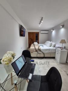 a bedroom with a desk with a laptop on a glass table at Arena Suite LR in La Rioja +8 photos