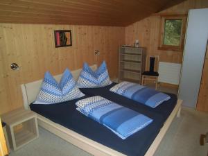 a bedroom with a bed with blue and white pillows at Fewo Zenger Jossi in Hasliberg