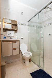 um banheiro com vaso sanitário e box de vidro em Pousada Império de Minas em Capitólio