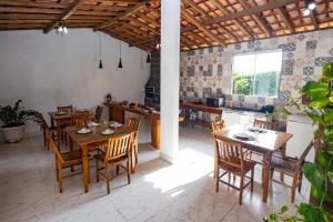 uma cozinha e sala de jantar com mesas e cadeiras de madeira em Pousada Império de Minas em Capitólio