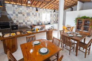 a kitchen with wooden tables and chairs in a room at Pousada Império de Minas in Capitólio