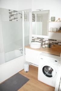 a white bathroom with a washing machine and a sink at Appartement Dunkerque in Dunkerque +10 photos