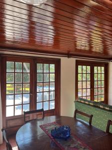 una sala da pranzo con un tavolo e alcune finestre di Casa dos Assentos a Quintiães