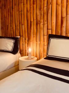 a bedroom with two beds and a wooden wall at Sunset Beach House in Zambujeira do Mar