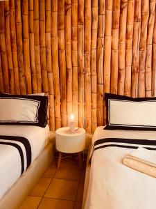 a bedroom with two beds and a bamboo wall at Sunset Beach House in Zambujeira do Mar