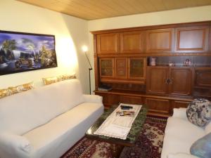 ein Wohnzimmer mit einer weißen Couch und einem Tisch in der Unterkunft Orpington in Dreisbach + 16 Fotos