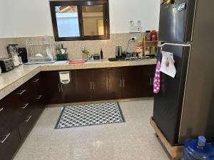 uma cozinha com uma geladeira preta e uma pia em Soglad Transient House em San Juan