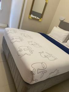 Cama en habitación con manta blanca en JH Guest house, en Durban