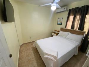 ein Schlafzimmer mit einem weißen Bett und einem Deckenventilator in der Unterkunft Increible Casa Con Piscina! in Los Frailes + 16 Fotos