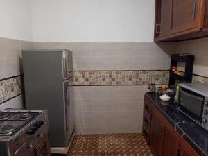 a small kitchen with a refrigerator and a stove at tasurft house imsoune in Imsouane +22 photos