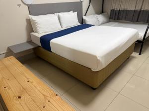 a large bed in a room with a wooden floor at JH Guest house in Durban