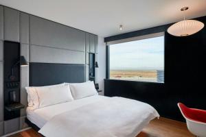 sypialnia z dużym białym łóżkiem i oknem w obiekcie citizenM Menlo Park w mieście Menlo Park +31 zdjęć