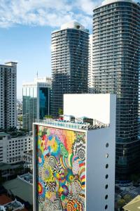 a painting on the side of a building with tall buildings at citizenM Miami Brickell in Miami