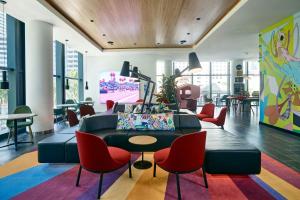 a living room with a couch and red chairs at citizenM Miami Brickell in Miami