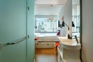 a bathroom with a sink and a bedroom with a bed at citizenM Miami Brickell in Miami +41 photos