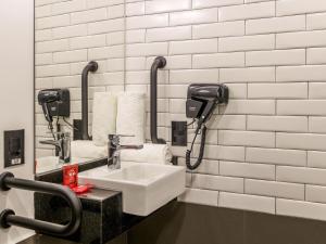 a bathroom with a sink and a phone at ibis Ribeirao Preto Vila do Golf in Ribeirão Preto