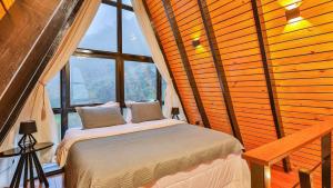 a bed in a room with a large window at Chalé A-Frame - Chalé de Cima in Ouro Preto +155 photos