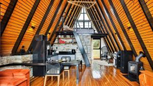 a large room with a fireplace and a table and chairs at Chalé A-Frame - Chalé de Cima in Ouro Preto