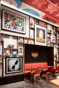 a restaurant with red chairs and a flat screen tv at citizenM San Francisco Union Square in San Francisco