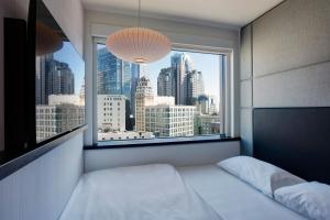 a bedroom with a view of a city from a window at citizenM San Francisco Union Square in San Francisco