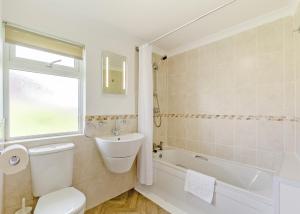 a bathroom with a toilet and a tub and a sink at Meadow Lakes Holiday Park in St Austell