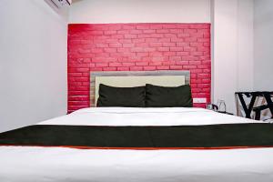 a bedroom with a red brick wall and a bed at Super Collection O Kalinga Bapuji Nagar in Bhubaneshwar +46 photos
