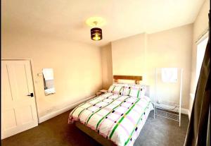 a bedroom with a bed with a striped comforter at Luxury Kingsize bedroom in a shared house in Chesterfield