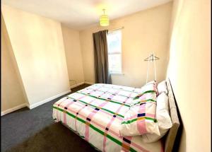 a bedroom with a bed with a colorful blanket at Luxury Kingsize bedroom in a shared house in Chesterfield