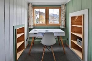 Cette chambre dispose d'un bureau et d'une chaise. dans l'établissement Haus Zum Reh, à Krummenau