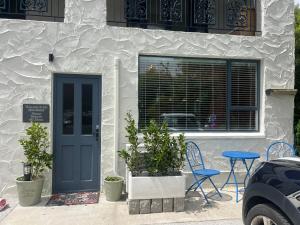 ein Haus mit einer blauen Tür sowie einem Tisch und Stühlen in der Unterkunft El Gran - Quiet, Central & Scenic Apartment in Wanaka