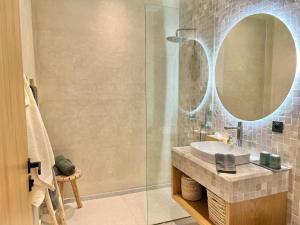 a bathroom with a sink and a glass shower at Villa AYA - Moderne & Chic in Sraghna +38 photos
