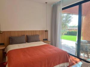a bedroom with a bed and a large window at Villa AYA - Moderne & Chic in Sraghna