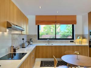 a kitchen with a table and a window at Villa AYA - Moderne & Chic in Sraghna