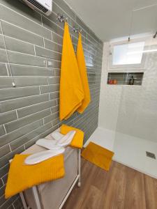 La salle de bains est pourvue d'une douche et de serviettes jaunes. dans l'établissement le stockholm, à Sablons 38 autres photos